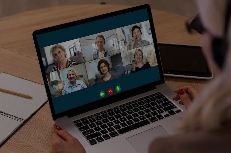 Video call with several people on a laptop screen.